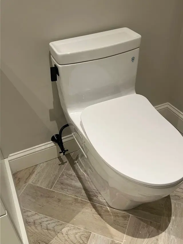 A newly installed toilet set against tiled walls