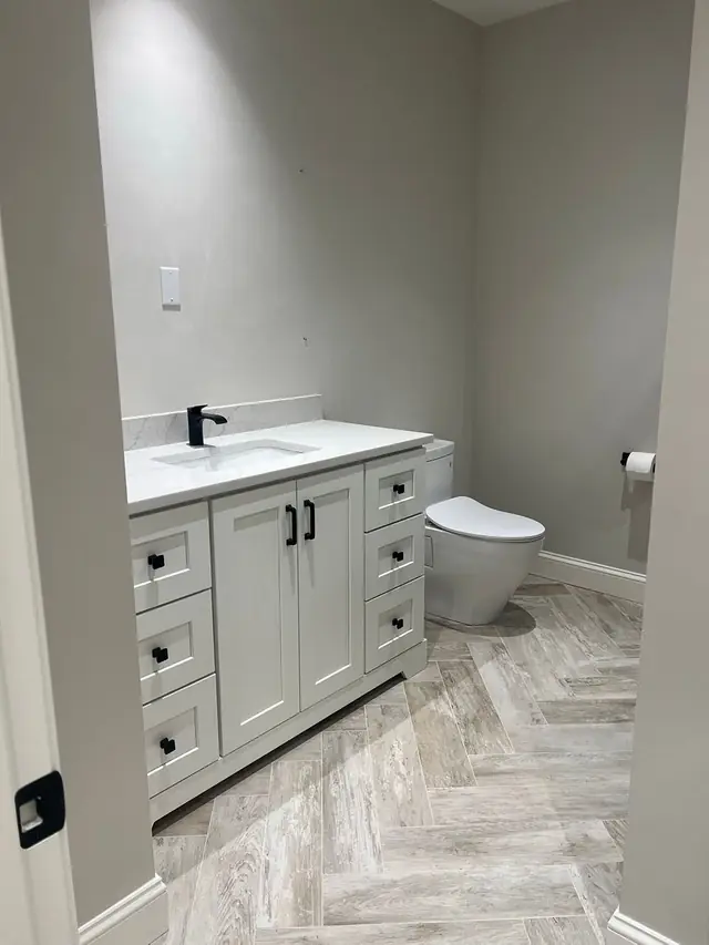A different bathroom finished with a herringbone tile floor