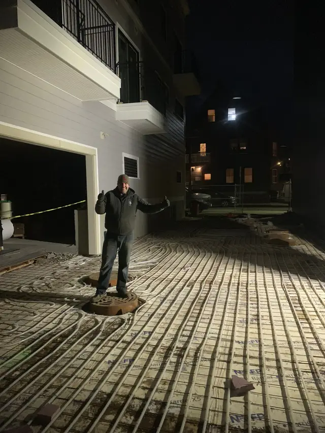 Radiant snowmelt tubing on a concrete slab, photographed at night